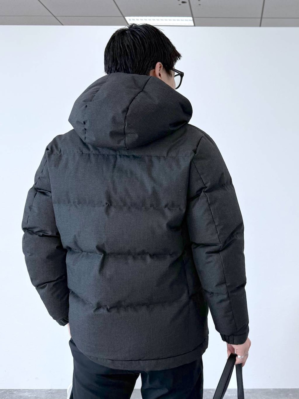 グレー系のダウンジャケット/コート、ブラック系のその他パンツ、ホワイト系のスウェットを着用したメンズの秋コーディネートの8枚目の写真