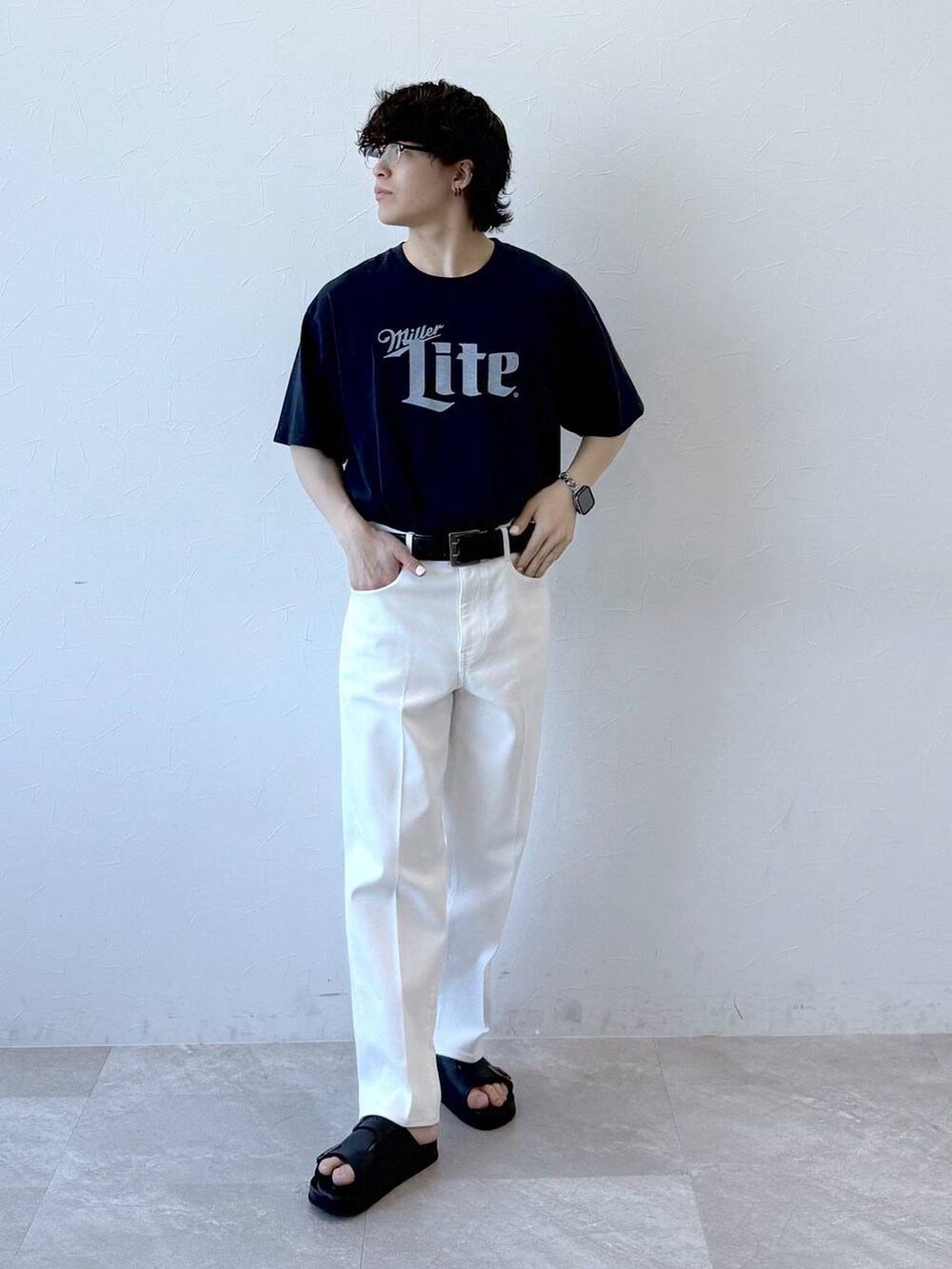 ブルー系のデニムパンツ、ブラック系のサンダル、ブルー系のTシャツ/カットソーを着用したメンズの夏コーディネートの2枚目の写真