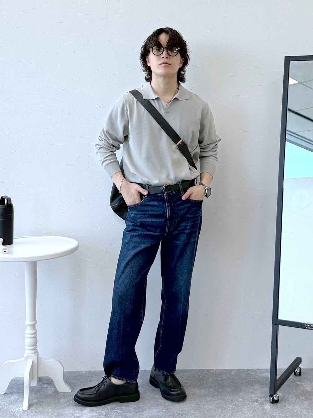 ブルー系のデニムパンツ、ベージュ系のニット/セーター、ブラック系のその他シューズを着用したメンズの秋コーディネートの2枚目の写真