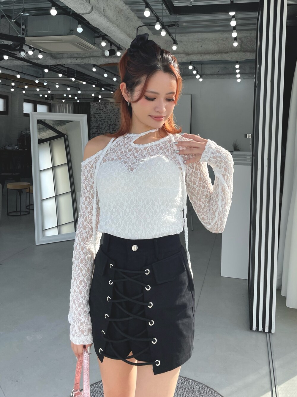 ホワイト系のTシャツ/カットソー、ブラック系のスカート、ブラック系のブーツを着用したレディースの冬コーディネートの2枚目の写真