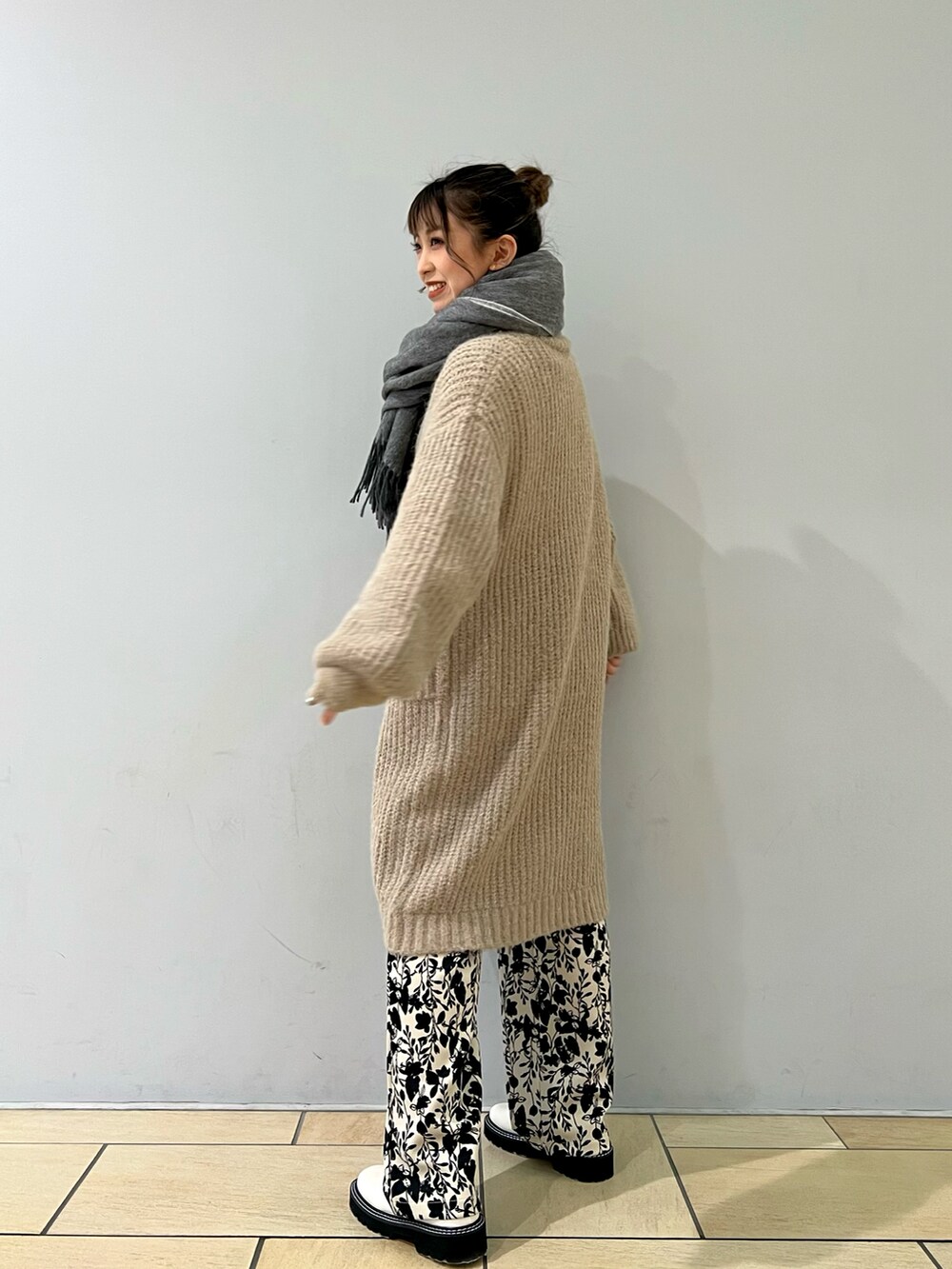 ベージュ系のカーディガン/ボレロ、ホワイト系のその他パンツ、イエロー系のニット/セーターを着用したレディースの冬コーディネートの2枚目の写真