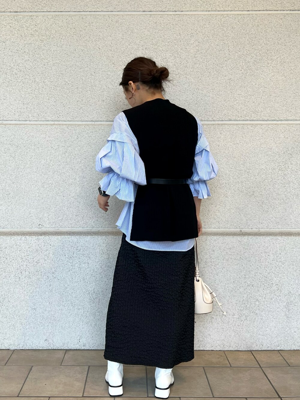 ホワイト系のショルダーバッグ、ブルー系のシャツ/ブラウス、ブラック系のベストを着用したレディースの冬コーディネートの3枚目の写真