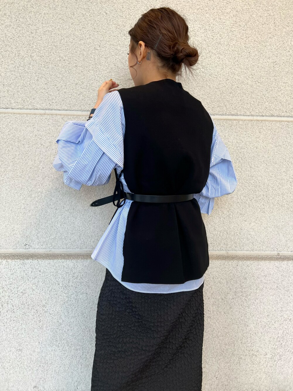 ホワイト系のショルダーバッグ、ブルー系のシャツ/ブラウス、ブラック系のベストを着用したレディースの冬コーディネートの4枚目の写真