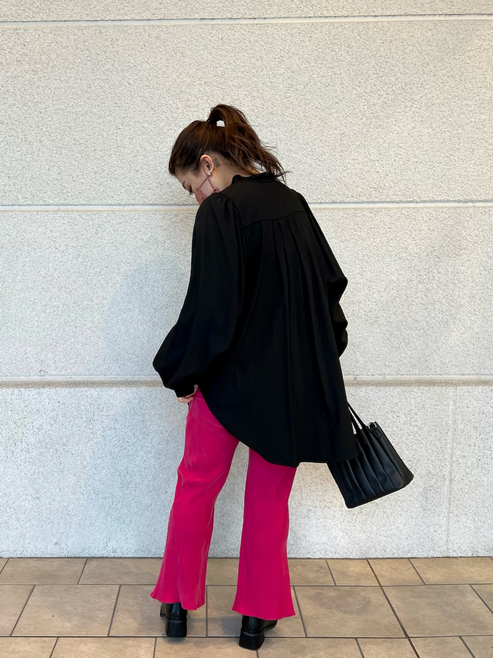 ブラック系のシャツ/ブラウス、ブラック系のハンドバッグ、ピンク系のスラックスを着用したレディースの冬コーディネートの3枚目の写真