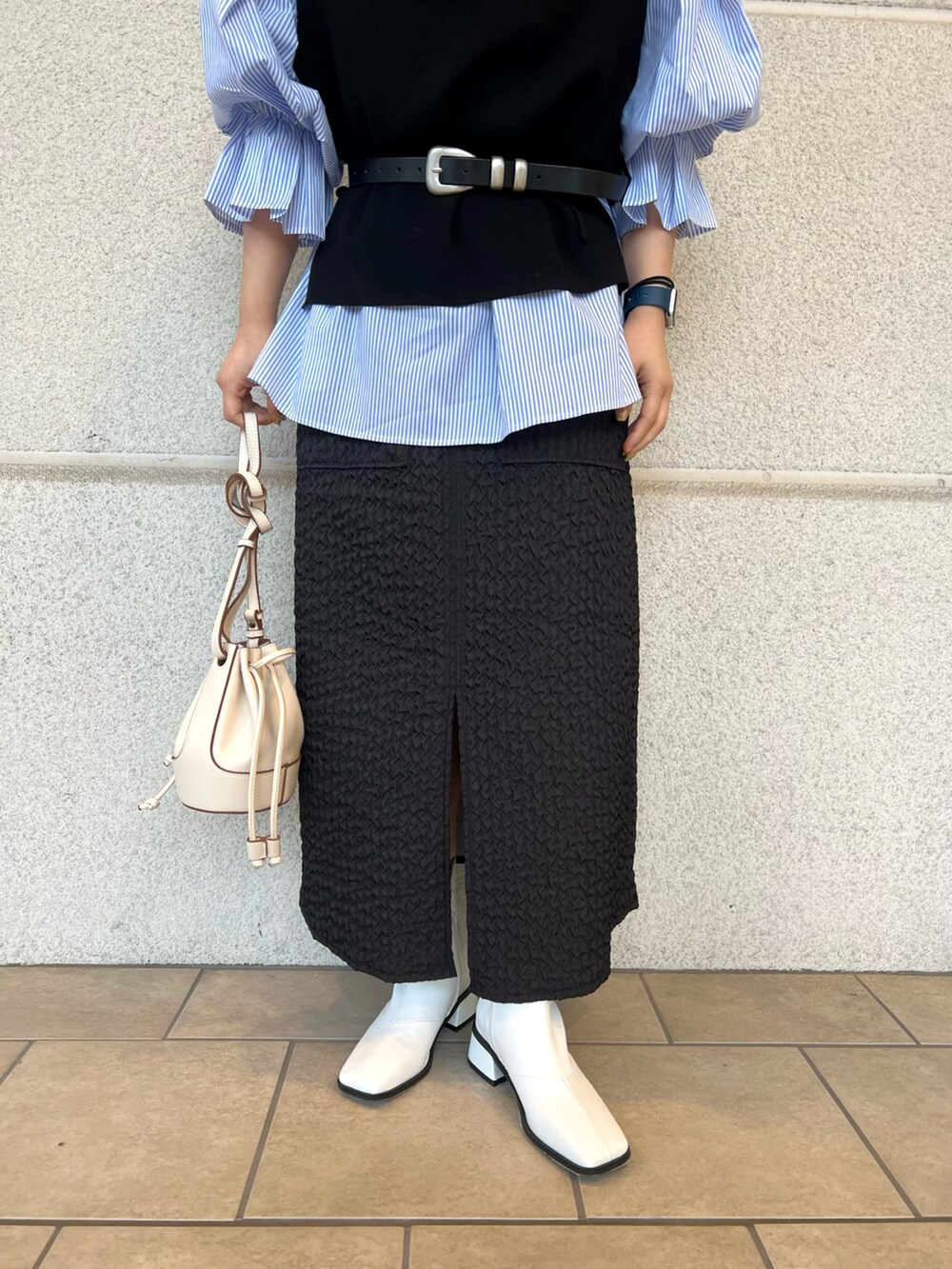 ホワイト系のショルダーバッグ、ブルー系のシャツ/ブラウス、ブラック系のベストを着用したレディースの冬コーディネートの5枚目の写真