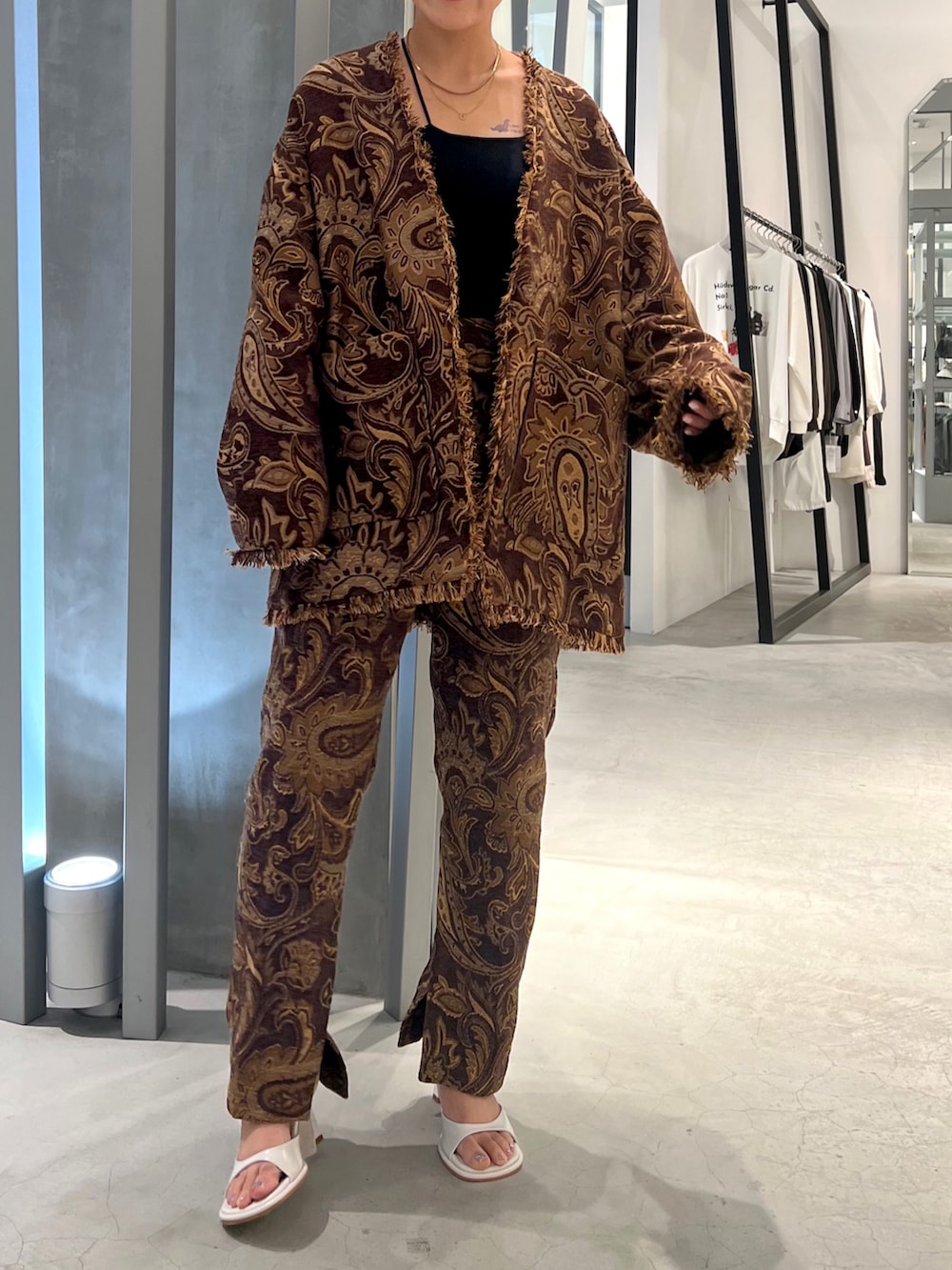 ブラウン系のノーカラージャケット、ブラウン系のその他パンツ、ホワイト系のサンダルを着用したレディースの秋コーディネートの4枚目の写真