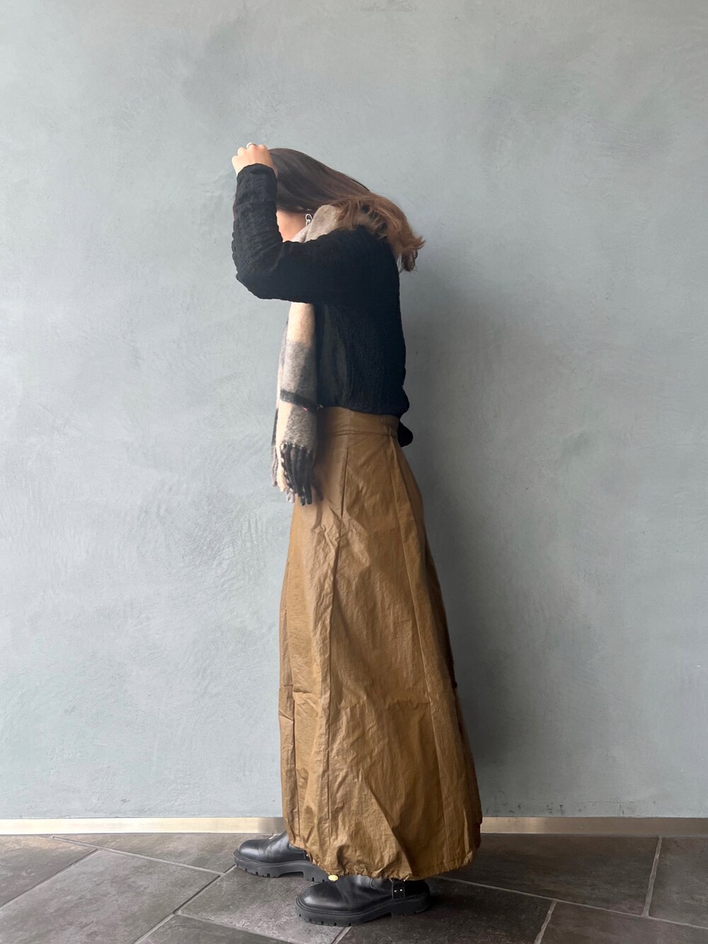 ブラック系のTシャツ/カットソー、グリーン系のスカート、グレー系のマフラーを着用したレディースの冬コーディネートの3枚目の写真