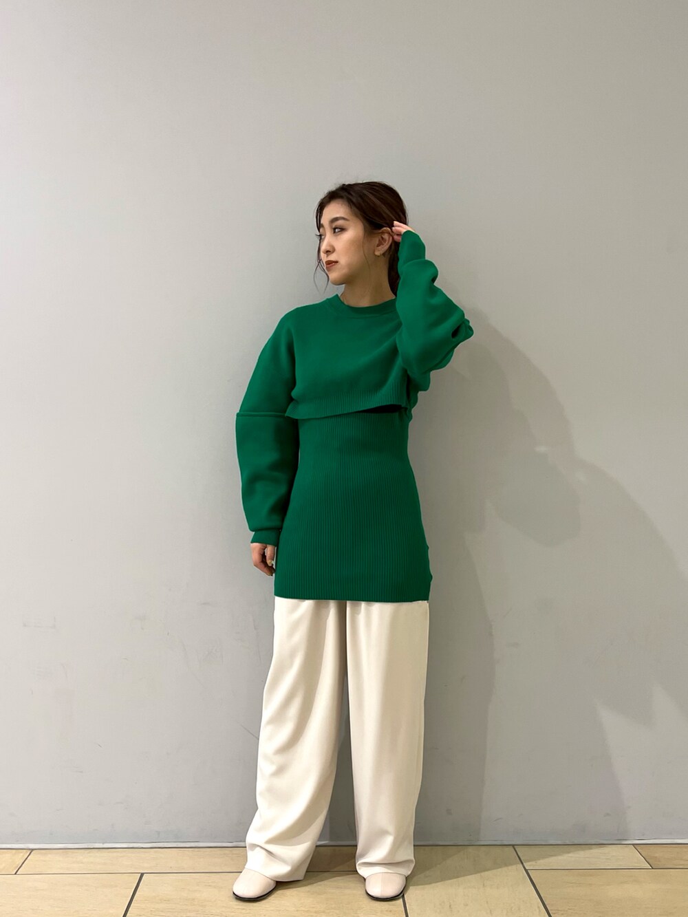 グリーン系のトップス、ホワイト系のパンツ、ホワイト系のブーツを着用したレディースの冬コーディネートの2枚目の写真