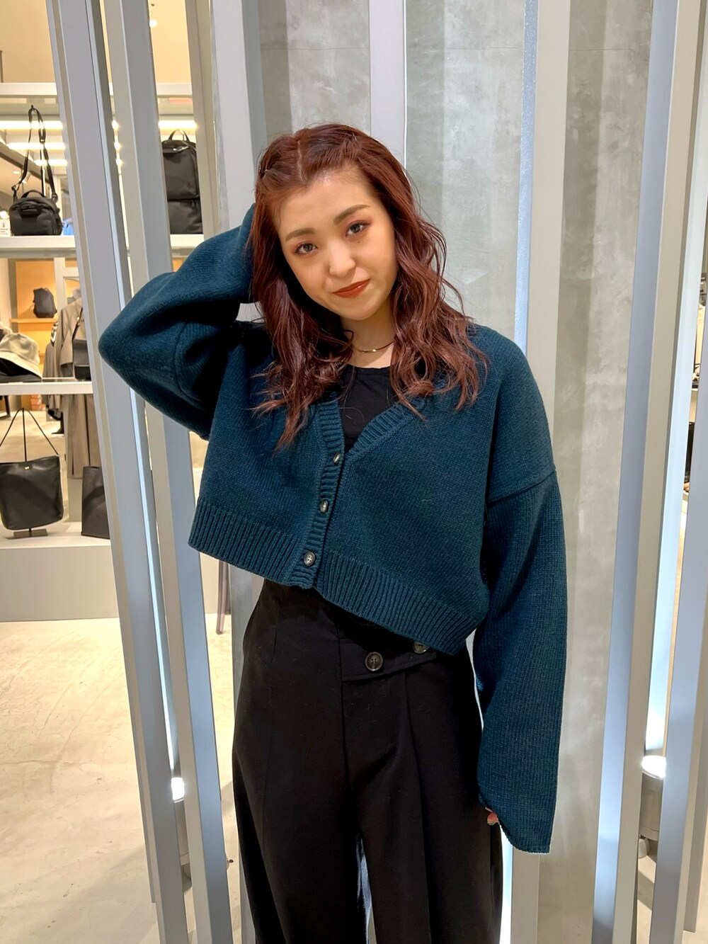 グリーン系のカーディガン/ボレロ、ブラック系のその他パンツ、ホワイト系のローファーを着用したレディースの冬コーディネートの5枚目の写真