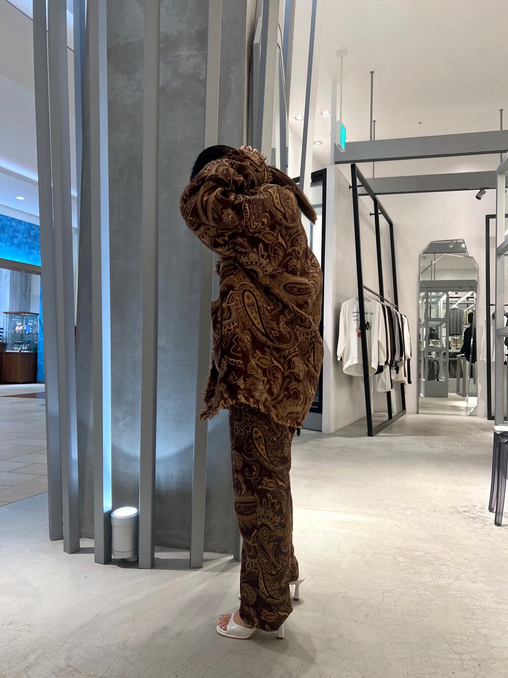 ブラウン系のノーカラージャケット、ブラウン系のその他パンツ、ホワイト系のサンダルを着用したレディースの秋コーディネートの2枚目の写真