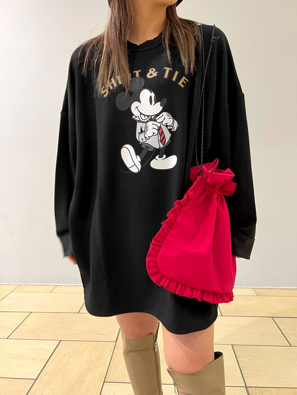 ブラック系のTシャツ/カットソー、レッド系のバッグ、ベージュ系のブーツを着用したレディースの冬コーディネートの3枚目の写真