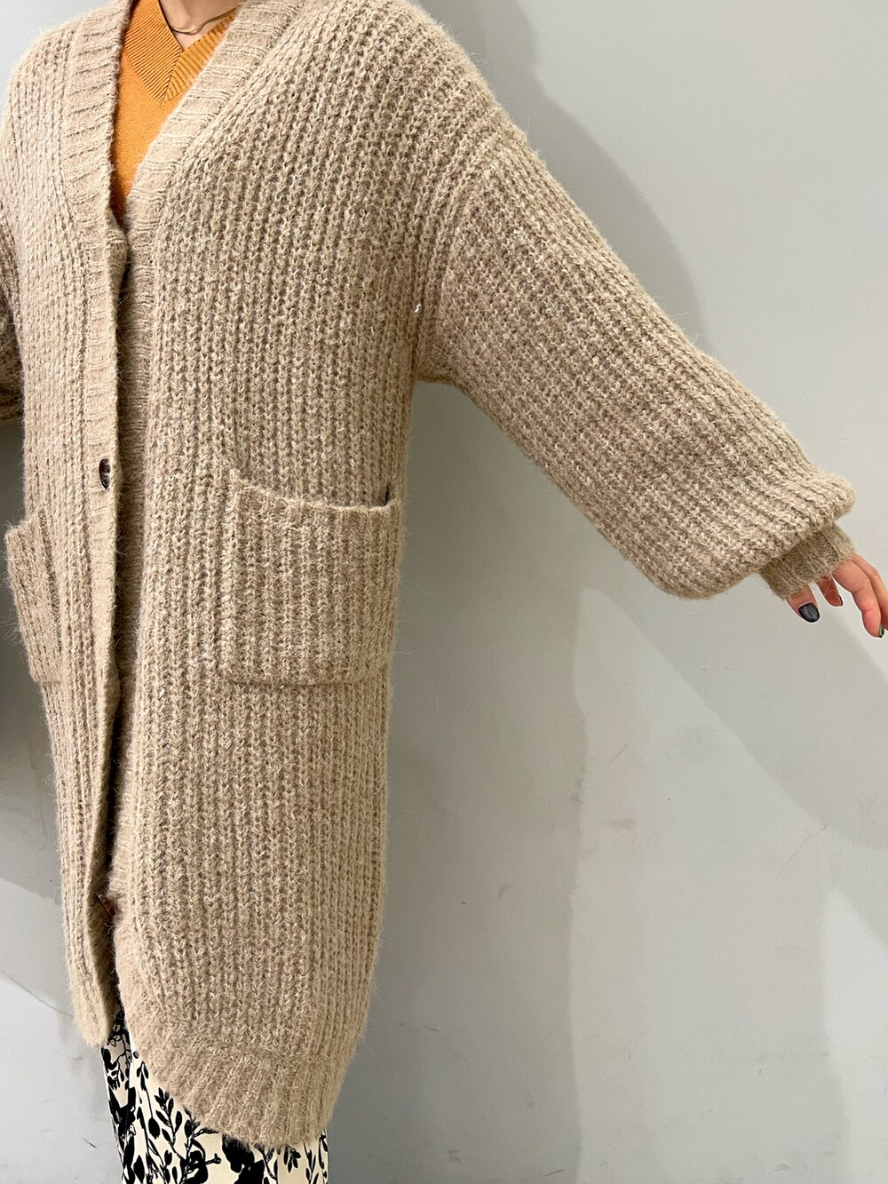 ベージュ系のカーディガン/ボレロ、ホワイト系のその他パンツ、イエロー系のニット/セーターを着用したレディースの冬コーディネートの3枚目の写真