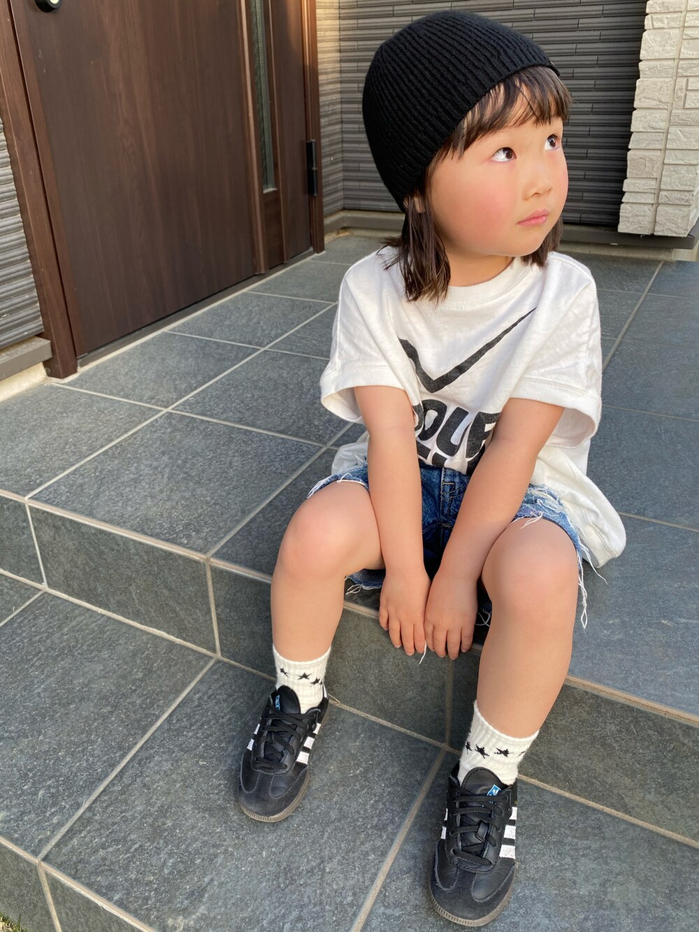 ホワイト系のTシャツ/カットソー、ブラック系のスニーカー、ブルー系のショーツを着用したキッズの春コーディネートの2枚目の写真