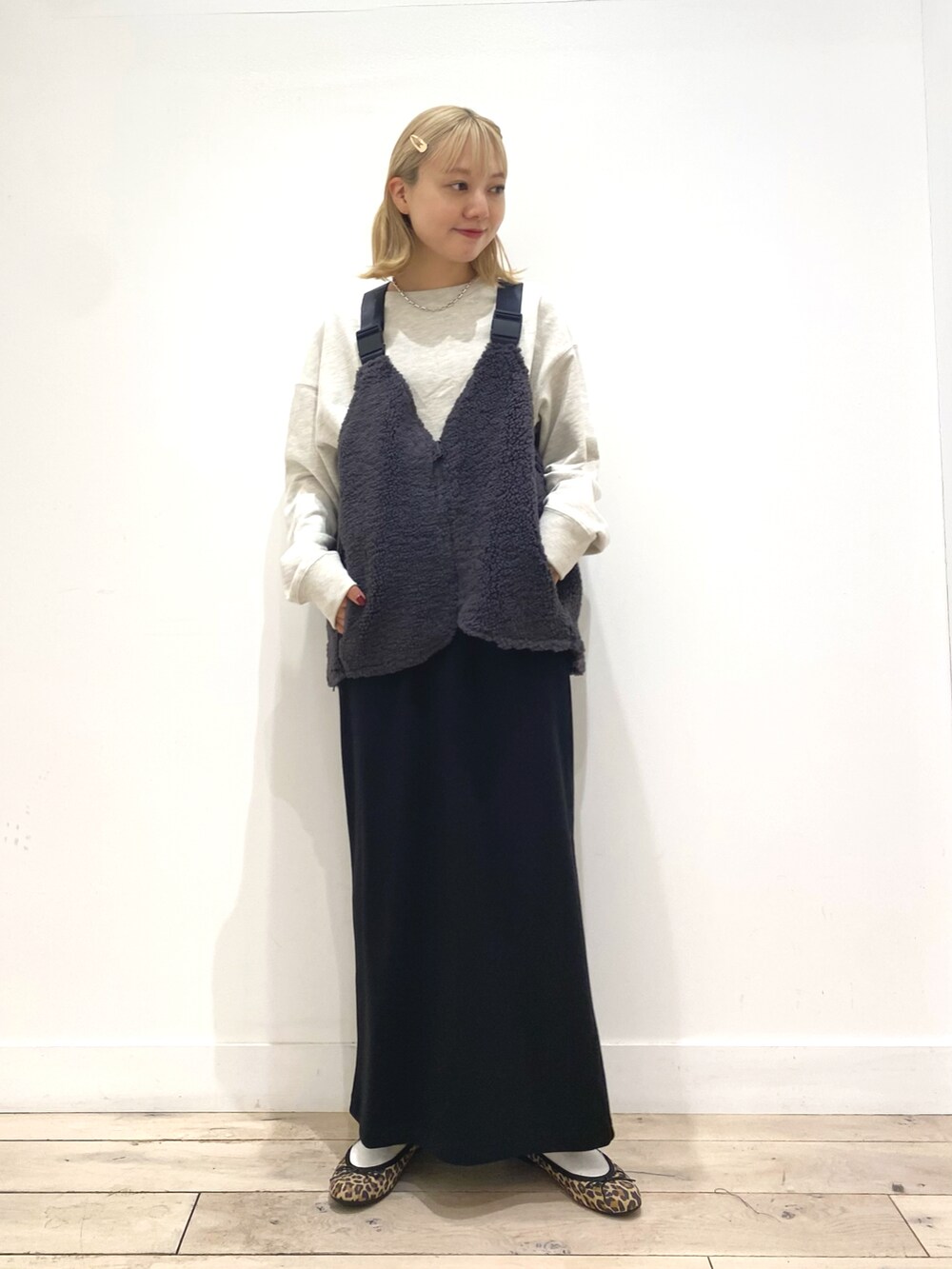 グレー系のベスト、グレー系のスカート、その他のバレエシューズを着用したレディースの秋コーディネートの2枚目の写真