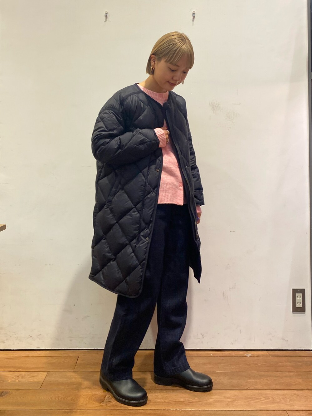 ピンク系のカーディガン/ボレロ、ブルー系のダウンジャケット/コート、ブルー系のデニムパンツを着用したレディースの冬コーディネートの3枚目の写真