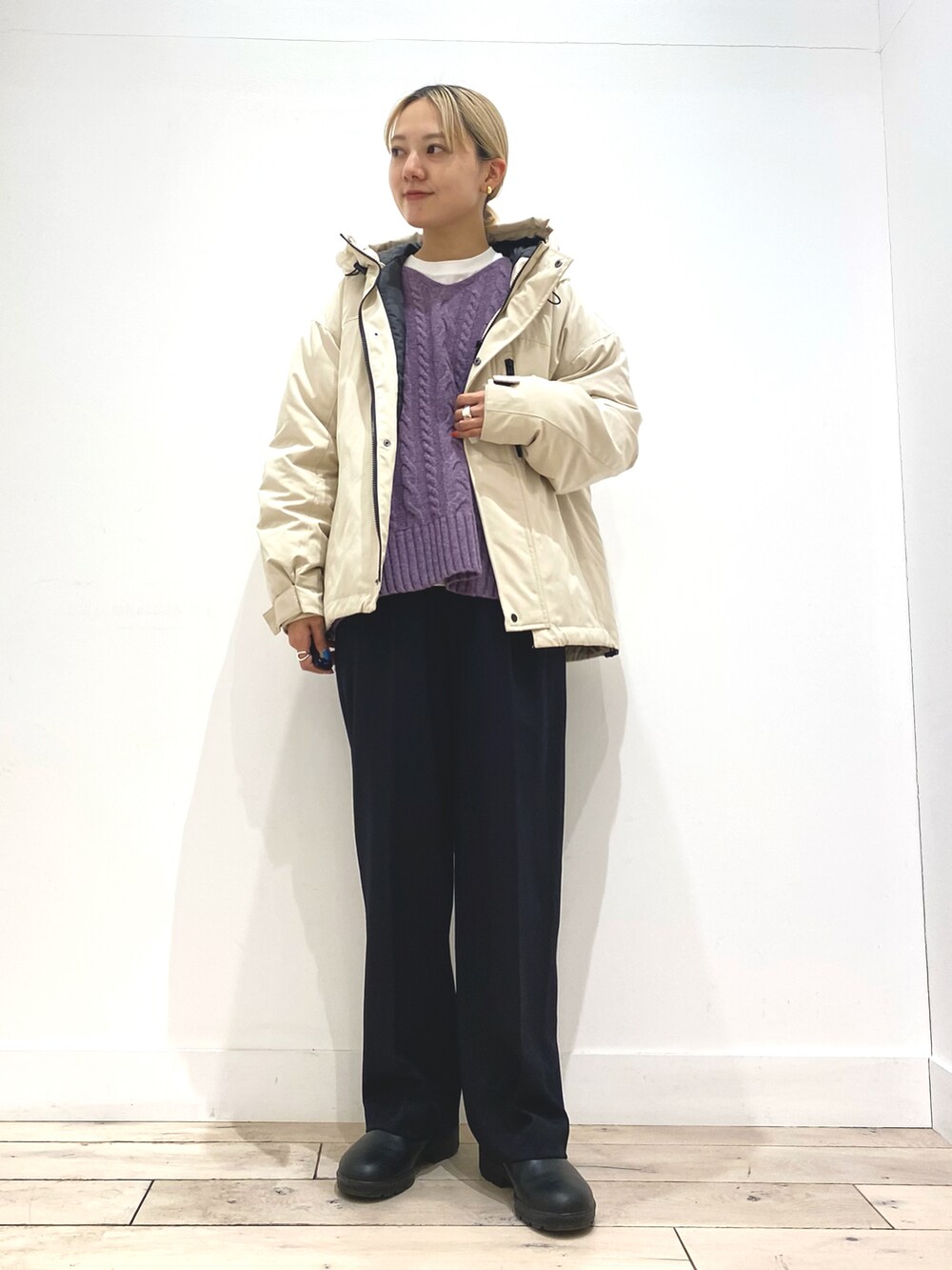 パープル系のニット/セーター、ホワイト系のTシャツ/カットソー、ベージュ系のダウンジャケット/コートを着用したレディースの秋コーディネートの2枚目の写真