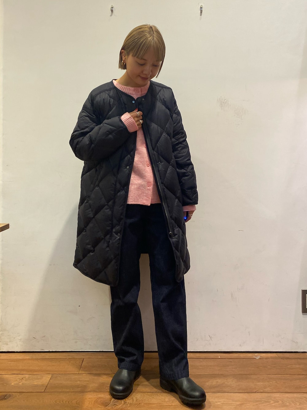 ピンク系のカーディガン/ボレロ、ブルー系のダウンジャケット/コート、ブルー系のデニムパンツを着用したレディースの冬コーディネートの2枚目の写真