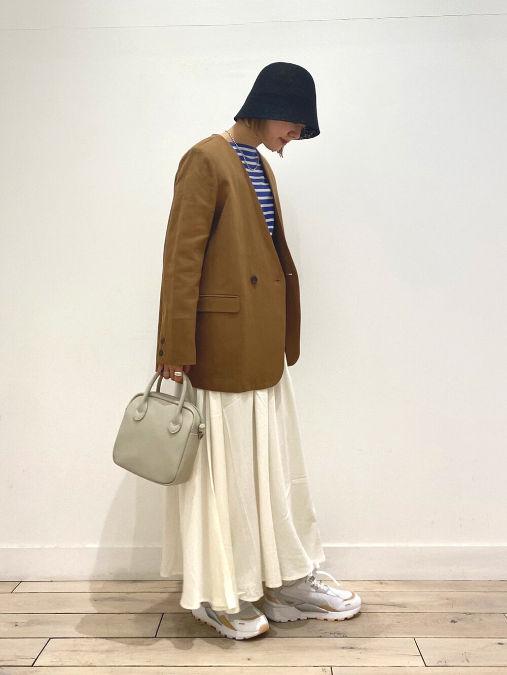 ブルー系のTシャツ/カットソー、ベージュ系のノーカラージャケット、ホワイト系のスカートを着用したレディースの春コーディネートの3枚目の写真