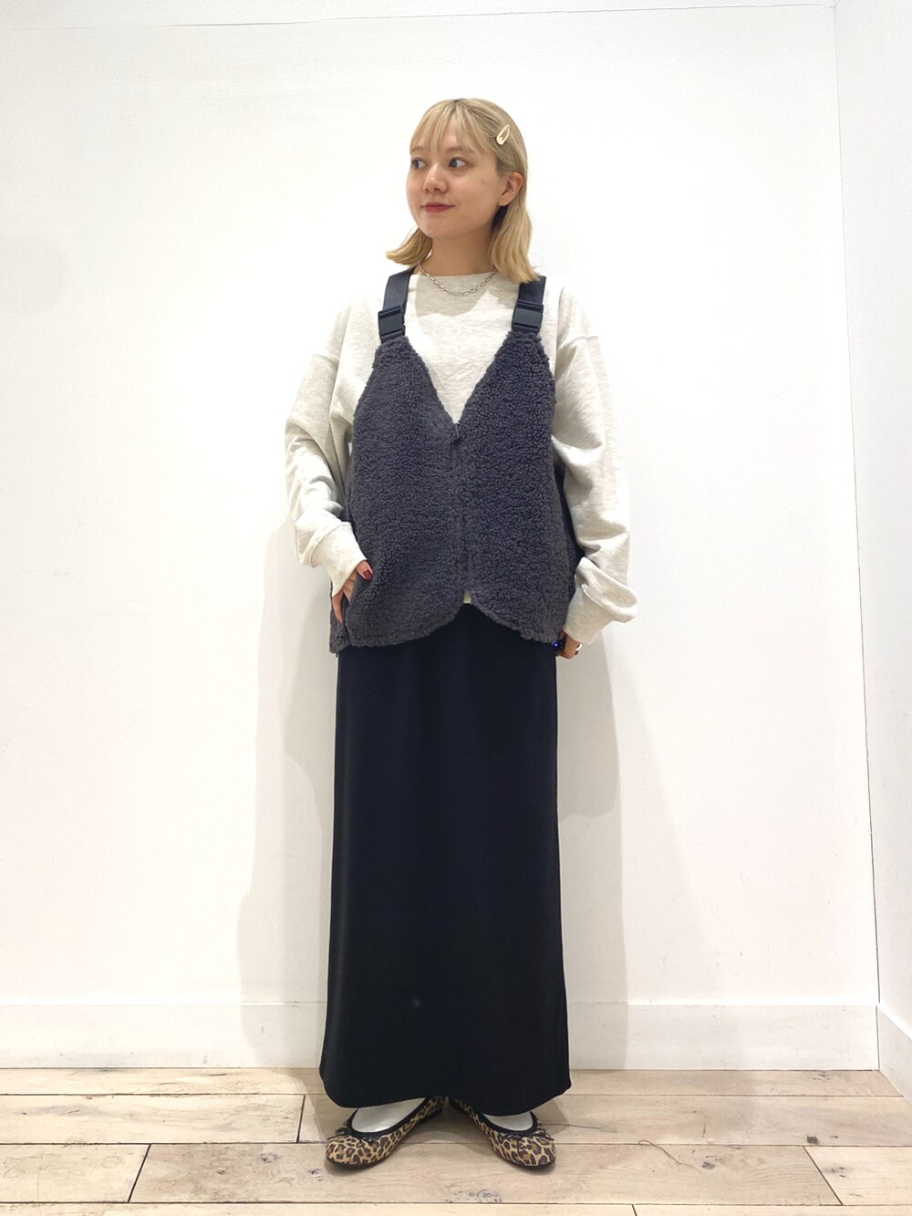 グレー系のベスト、グレー系のスカート、その他のバレエシューズを着用したレディースの秋コーディネートの3枚目の写真