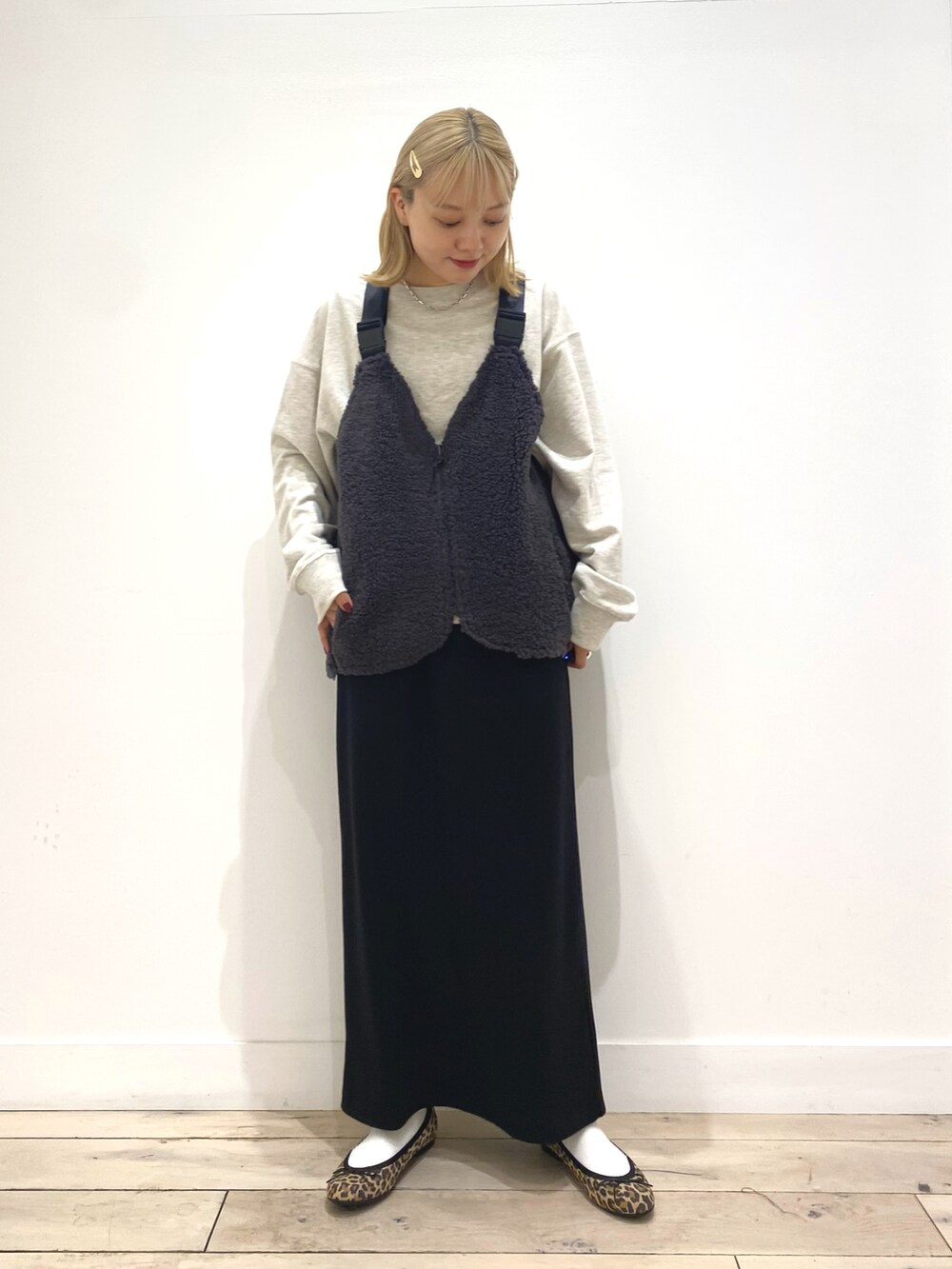 グレー系のベスト、グレー系のスカート、その他のバレエシューズを着用したレディースの秋コーディネートの4枚目の写真