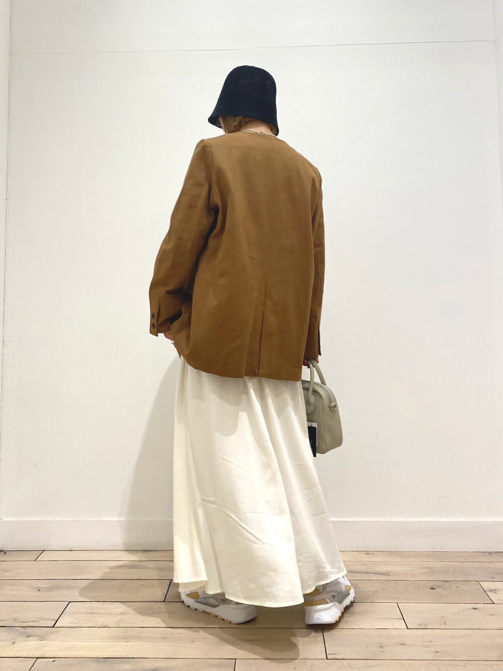 ブルー系のTシャツ/カットソー、ベージュ系のノーカラージャケット、ホワイト系のスカートを着用したレディースの春コーディネートの4枚目の写真