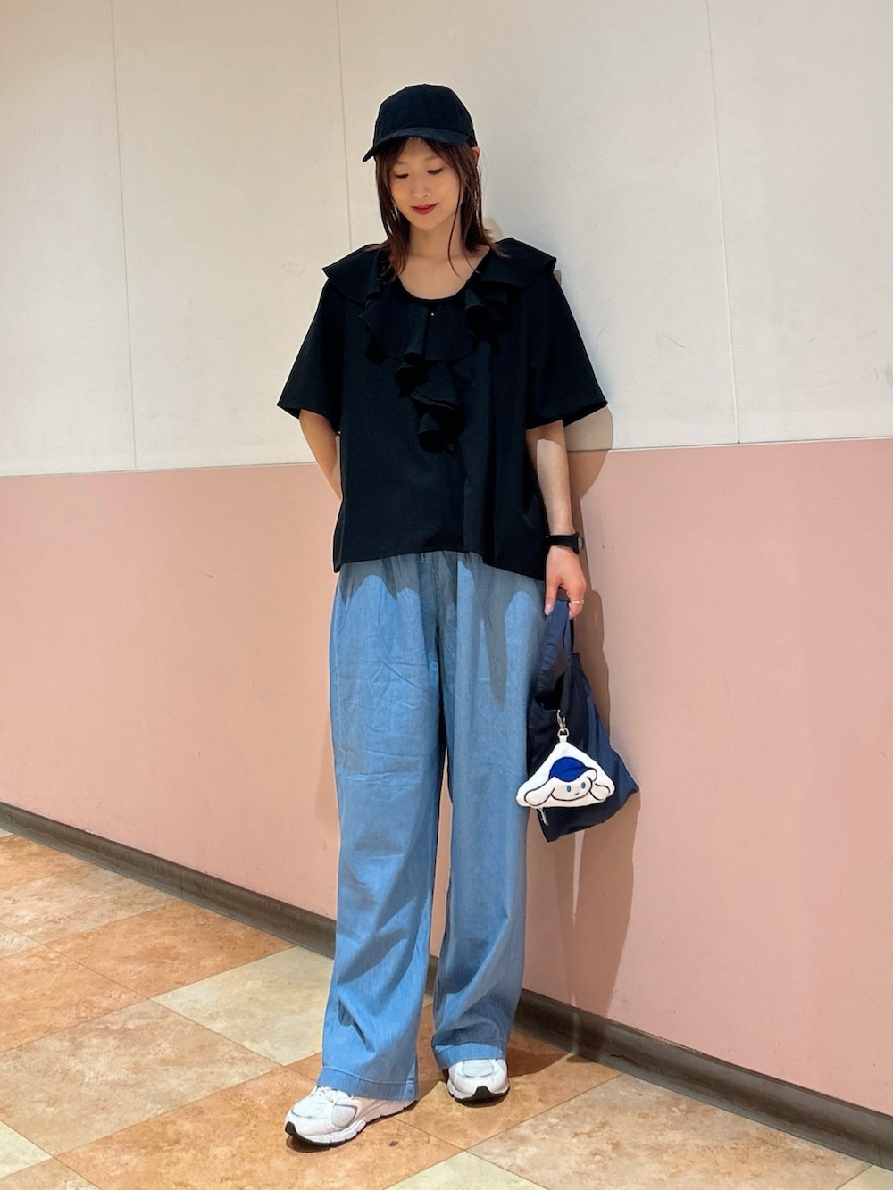 ブルー系のデニムパンツ、ブラック系のタンクトップ、ブルー系のエコバッグ/サブバッグを着用したレディースの春コーディネートの3枚目の写真
