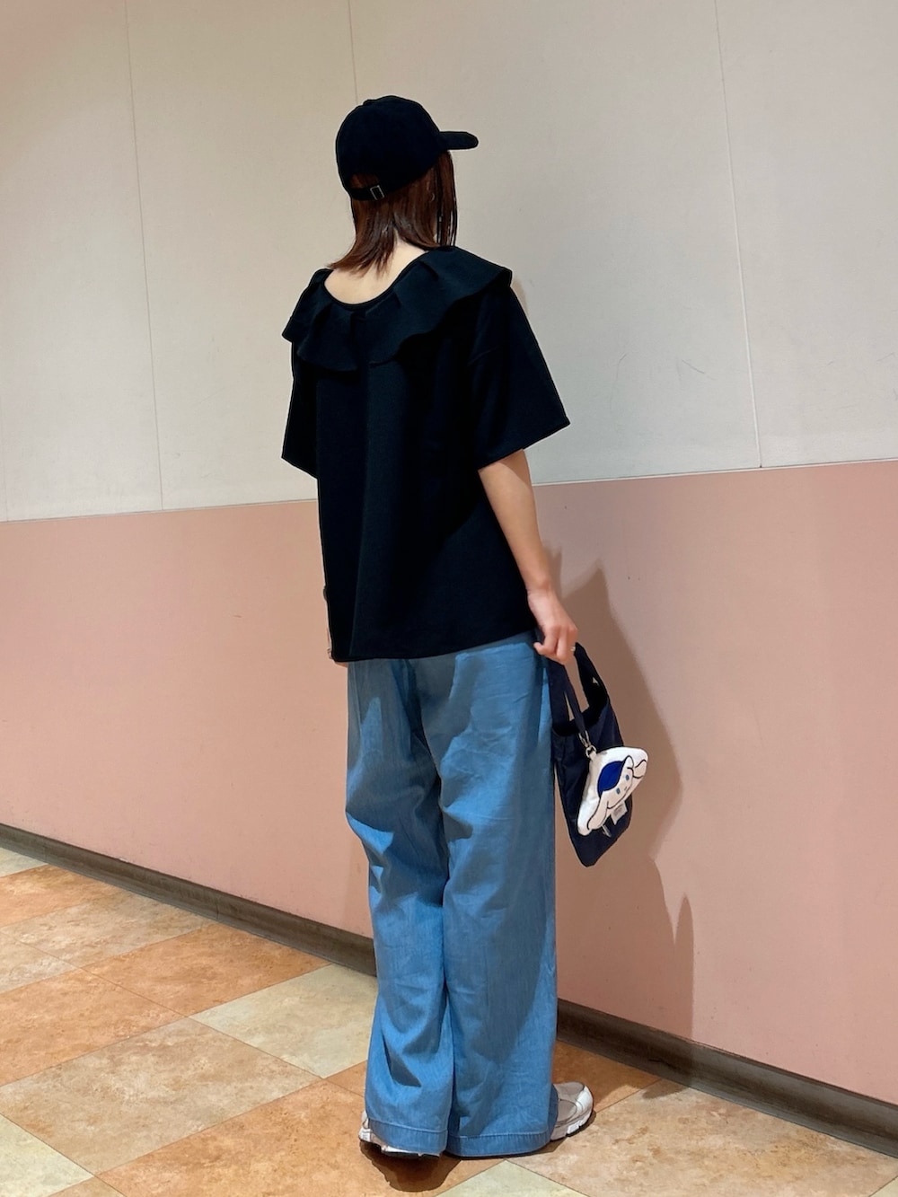 ブルー系のデニムパンツ、ブラック系のタンクトップ、ブルー系のエコバッグ/サブバッグを着用したレディースの春コーディネートの5枚目の写真