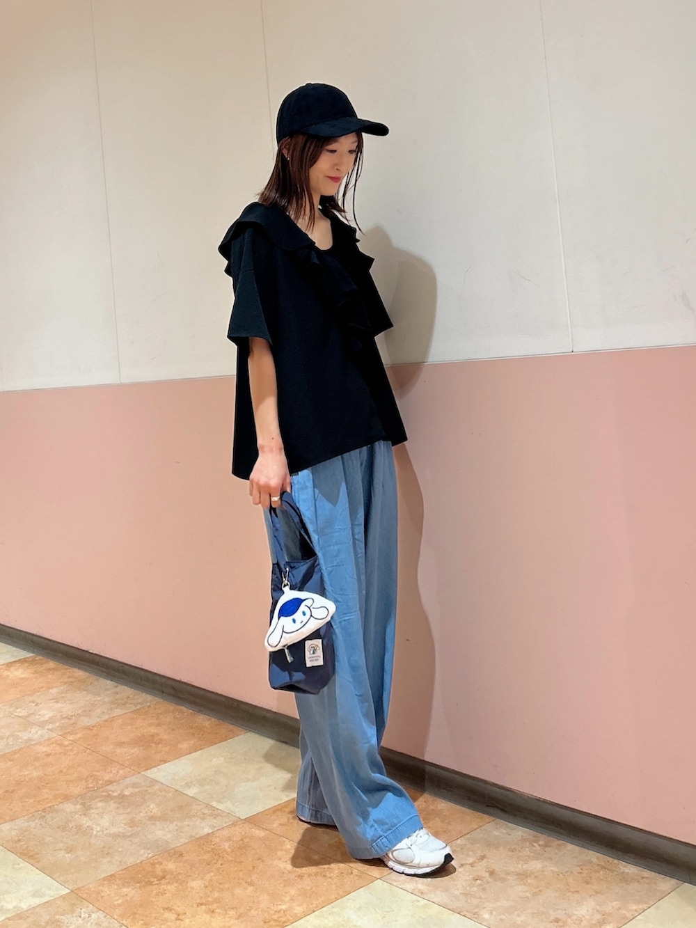 ブルー系のデニムパンツ、ブラック系のタンクトップ、ブルー系のエコバッグ/サブバッグを着用したレディースの春コーディネートの6枚目の写真