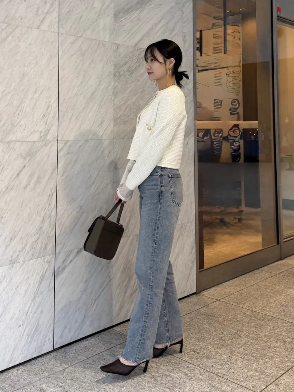 ホワイト系のTシャツ/カットソー、ホワイト系のノーカラージャケット、ブルー系のデニムパンツを着用したレディースの冬コーディネートの2枚目の写真