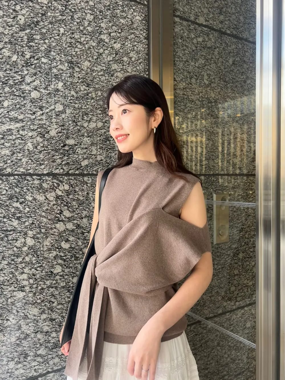 ブラウン系のニット/セーター、ホワイト系のスカートを着用したレディースの春コーディネートの3枚目の写真