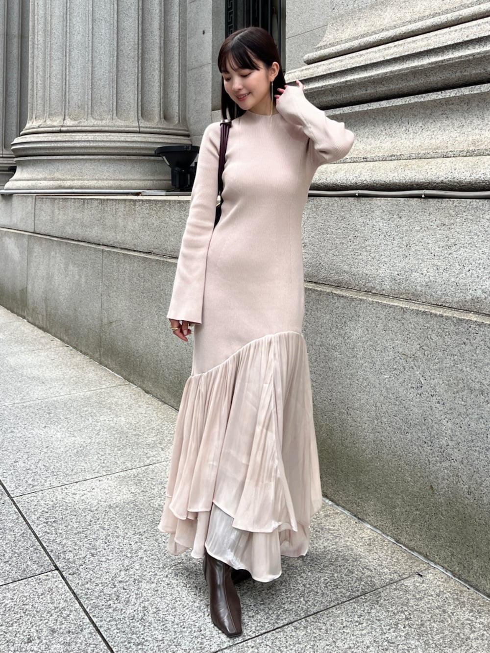 ピンク系のワンピースを着用したレディースの冬コーディネートの2枚目の写真