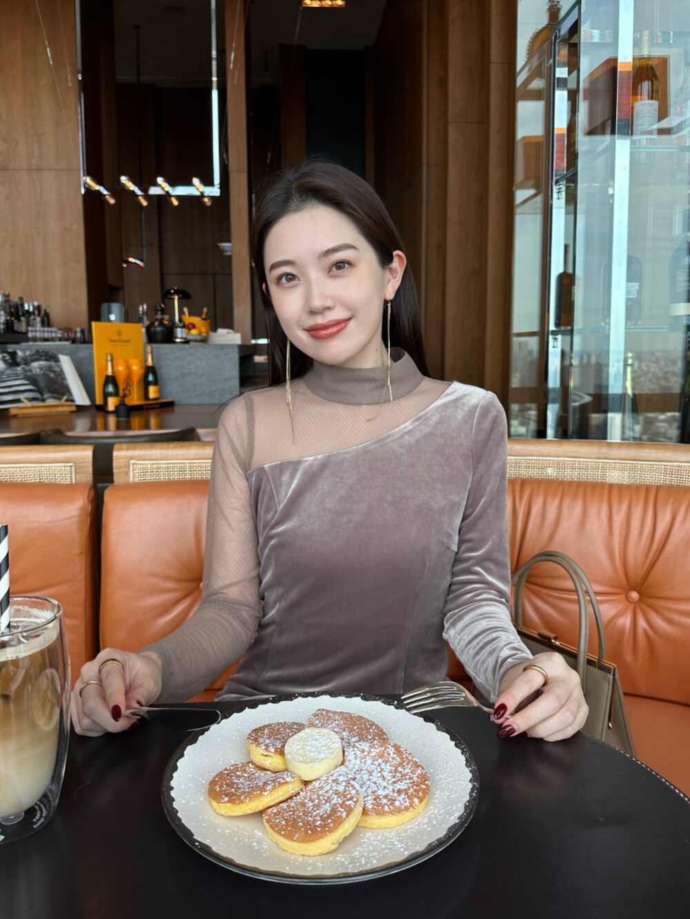 ベージュ系のハンドバッグ、ブラック系のブーツ、ベージュ系のワンピースを着用したレディースの冬コーディネートの5枚目の写真