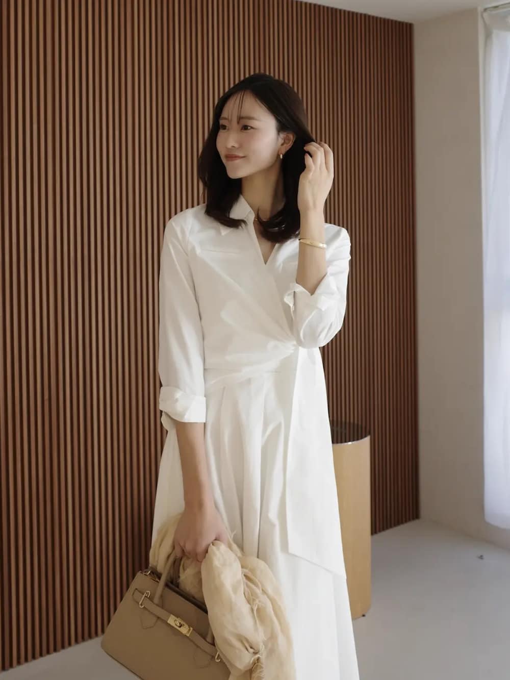 ホワイト系のシャツワンピースを着用したレディースの春コーディネートの5枚目の写真