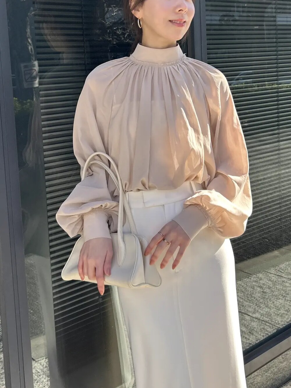 ピンク系のシャツ/ブラウス、ホワイト系のスカートを着用したレディースの冬コーディネートの3枚目の写真