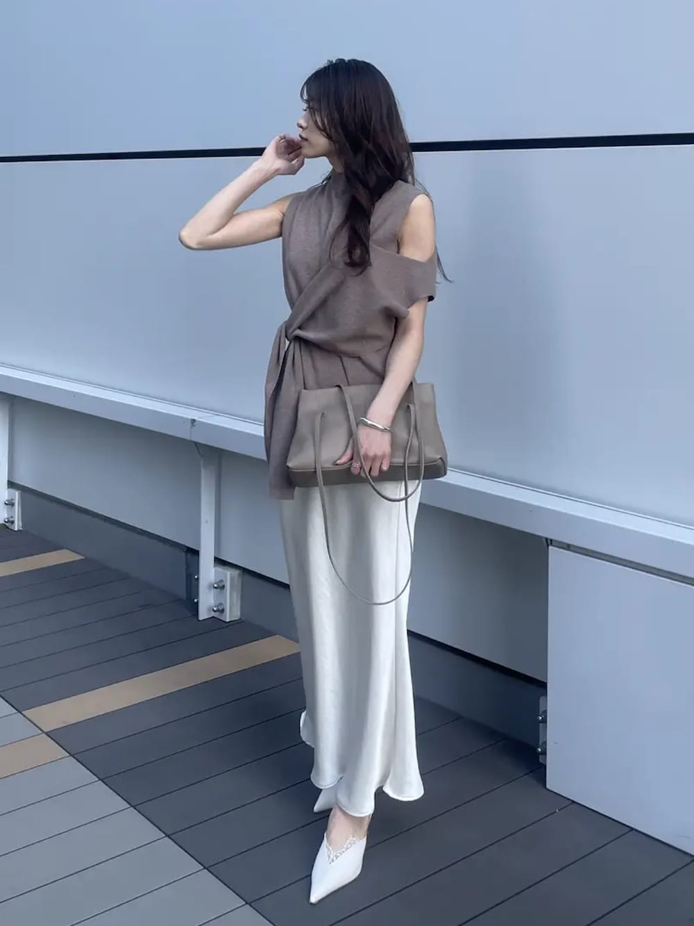 ブラウン系のニット/セーターを着用したレディースの春コーディネートの2枚目の写真