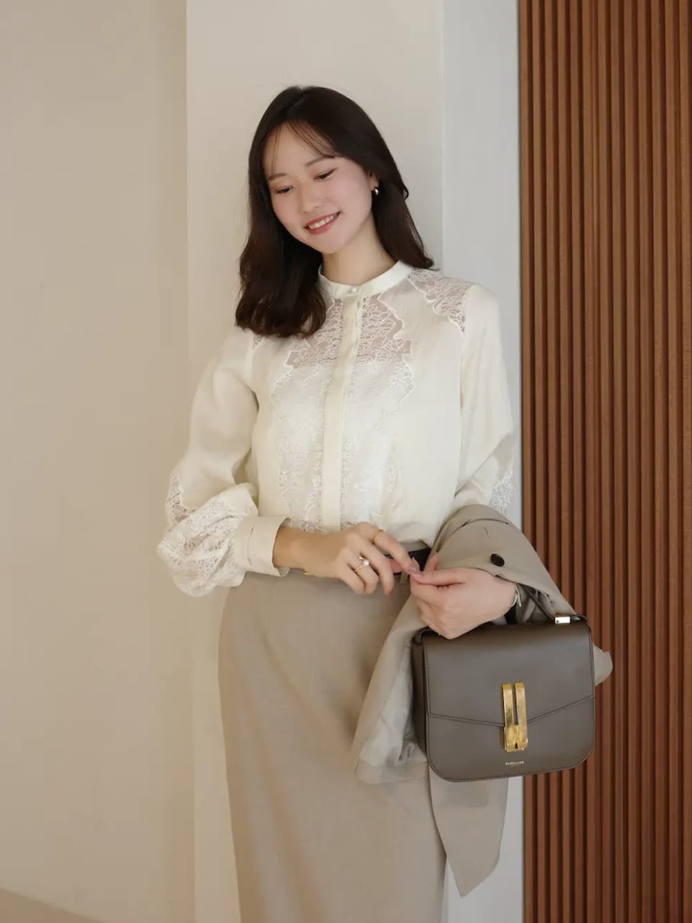 ベージュ系のテーラードジャケット、ホワイト系のシャツ/ブラウス、ベージュ系のスカートを着用したレディースの春コーディネートの3枚目の写真