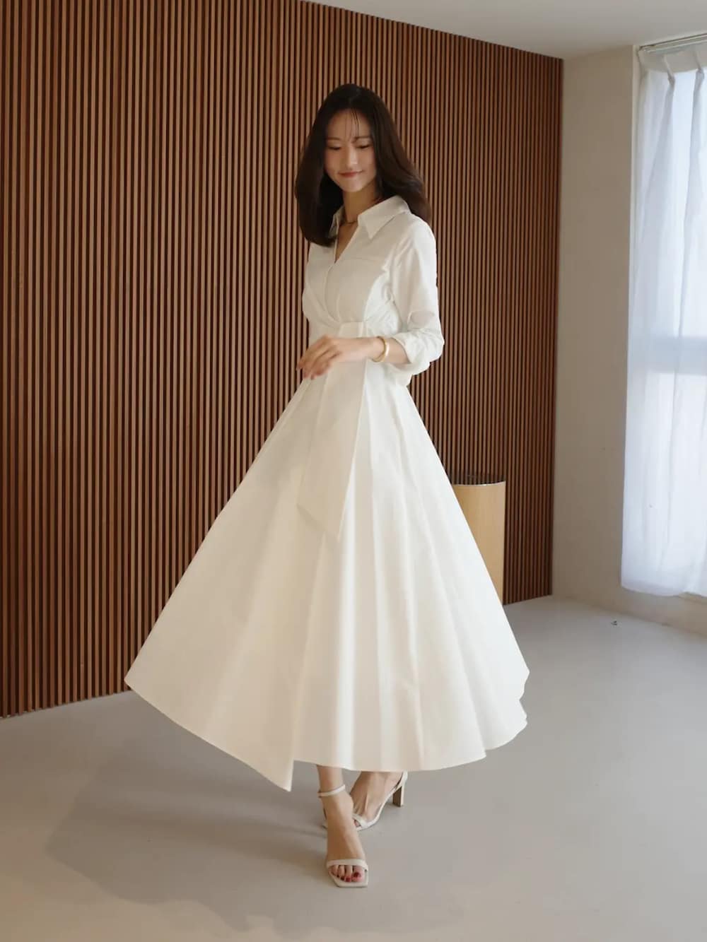 ホワイト系のシャツワンピースを着用したレディースの春コーディネートの2枚目の写真