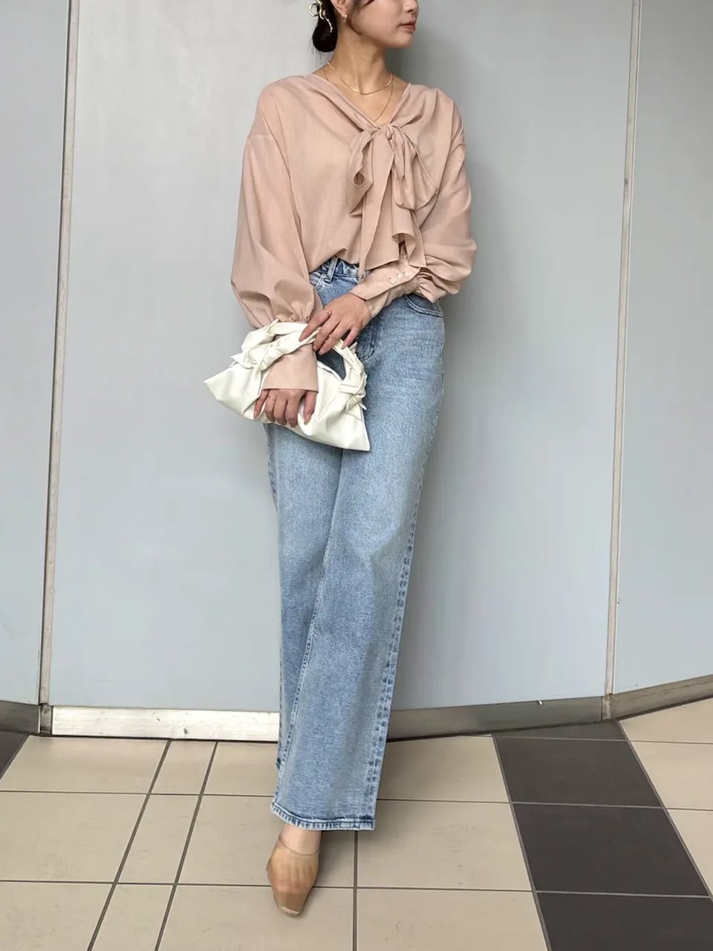 ピンク系のシャツ/ブラウス、ブルー系のデニムパンツを着用したレディースの春コーディネートの3枚目の写真