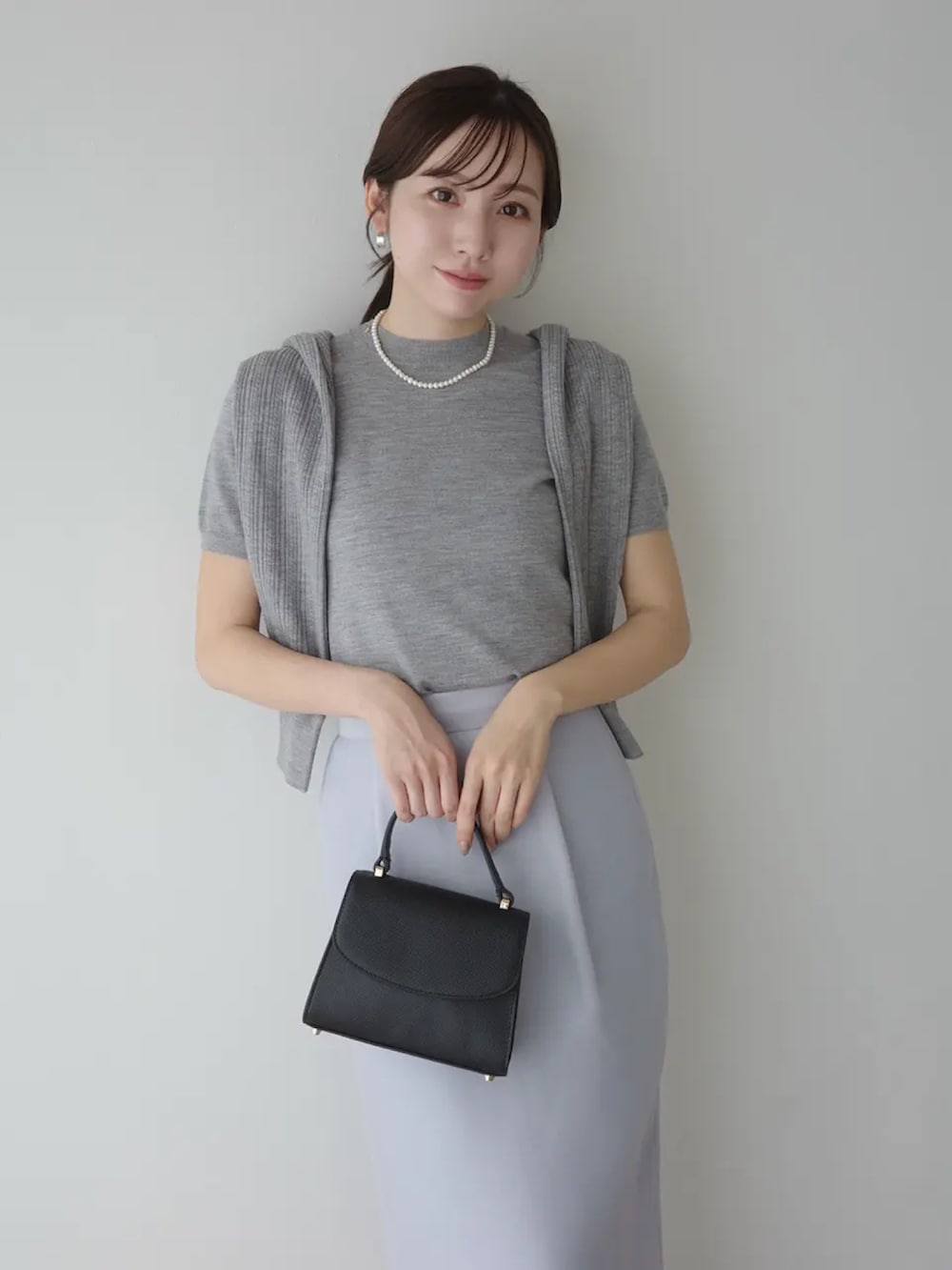 ブルー系のスカート、グレー系のその他トップス、グレー系のカーディガン/ボレロを着用したレディースの春コーディネートの2枚目の写真