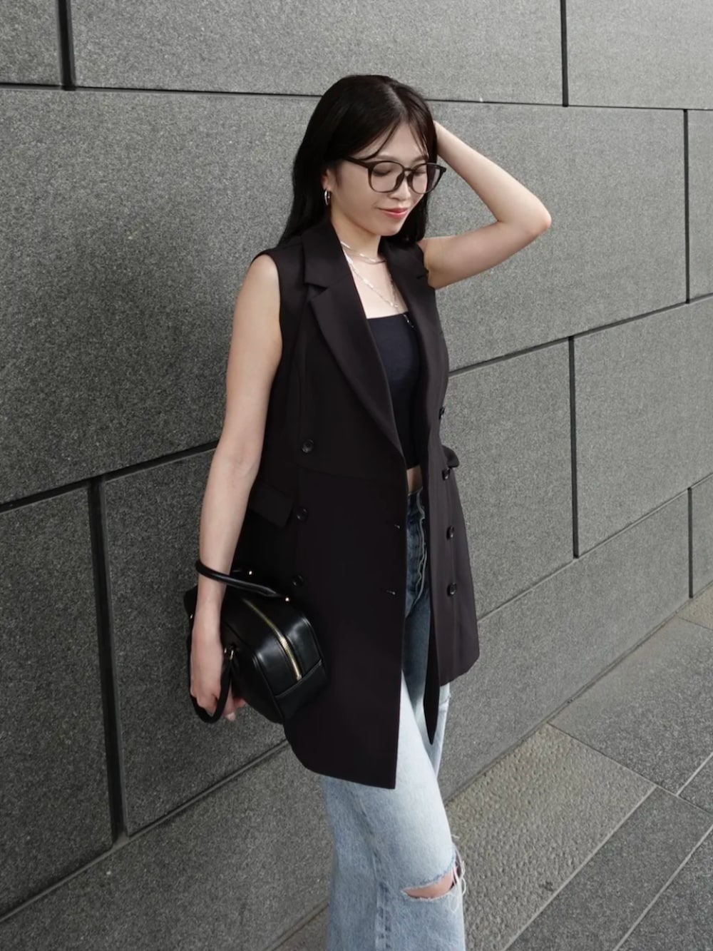ブルー系のデニムパンツ、ブラック系のサンダル、ブラック系のキャミソールを着用したレディースの秋コーディネートの3枚目の写真