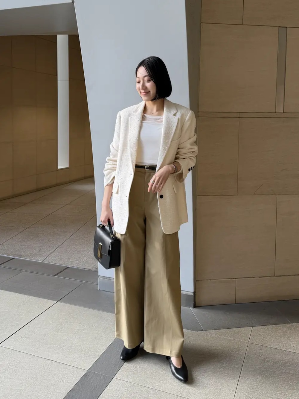 ホワイト系のその他アウター、ホワイト系のTシャツ/カットソー、ベージュ系のその他パンツを着用したレディースの冬コーディネートの5枚目の写真