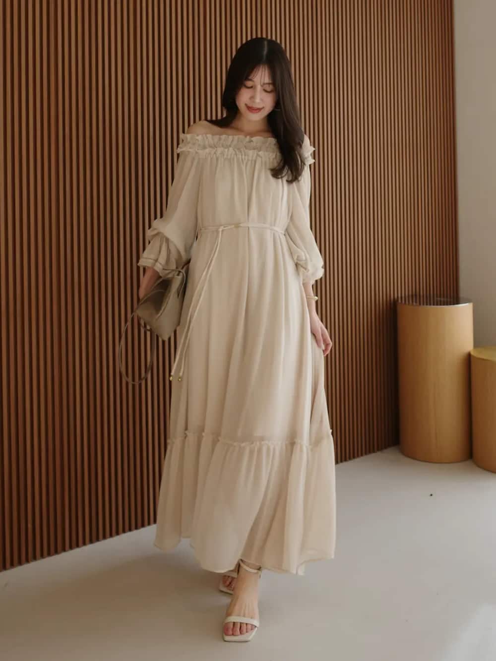 ベージュ系のワンピースを着用したレディースの春コーディネートの2枚目の写真