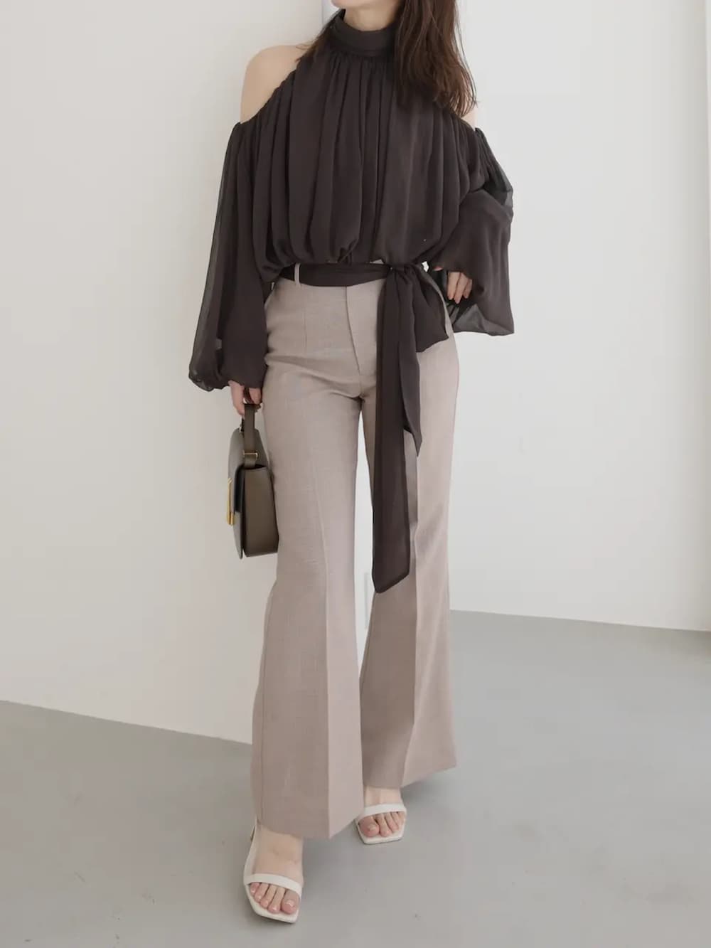 ブラウン系のシャツ/ブラウス、ベージュ系のスラックスを着用したレディースの春コーディネートの3枚目の写真