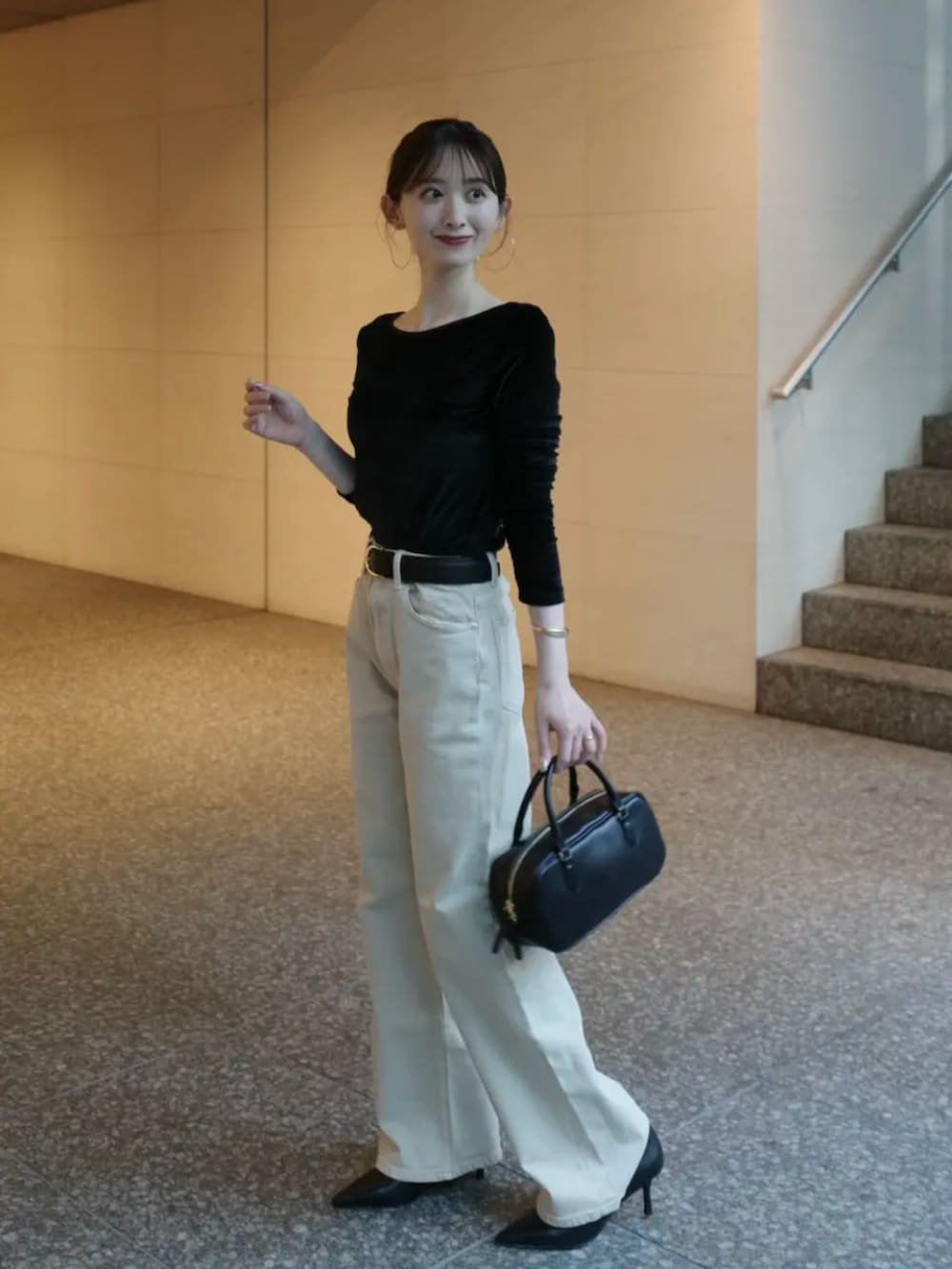 ベージュ系のデニムパンツ、ブラック系のボストンバッグ、ブラック系のパンプスを着用したレディースの夏コーディネートの2枚目の写真