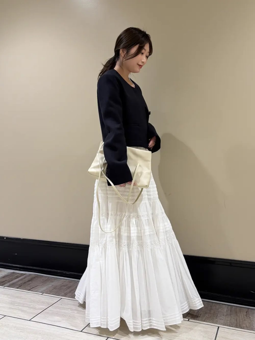 ブルー系のノーカラージャケット、ホワイト系のスカートを着用したレディースの春コーディネートの2枚目の写真