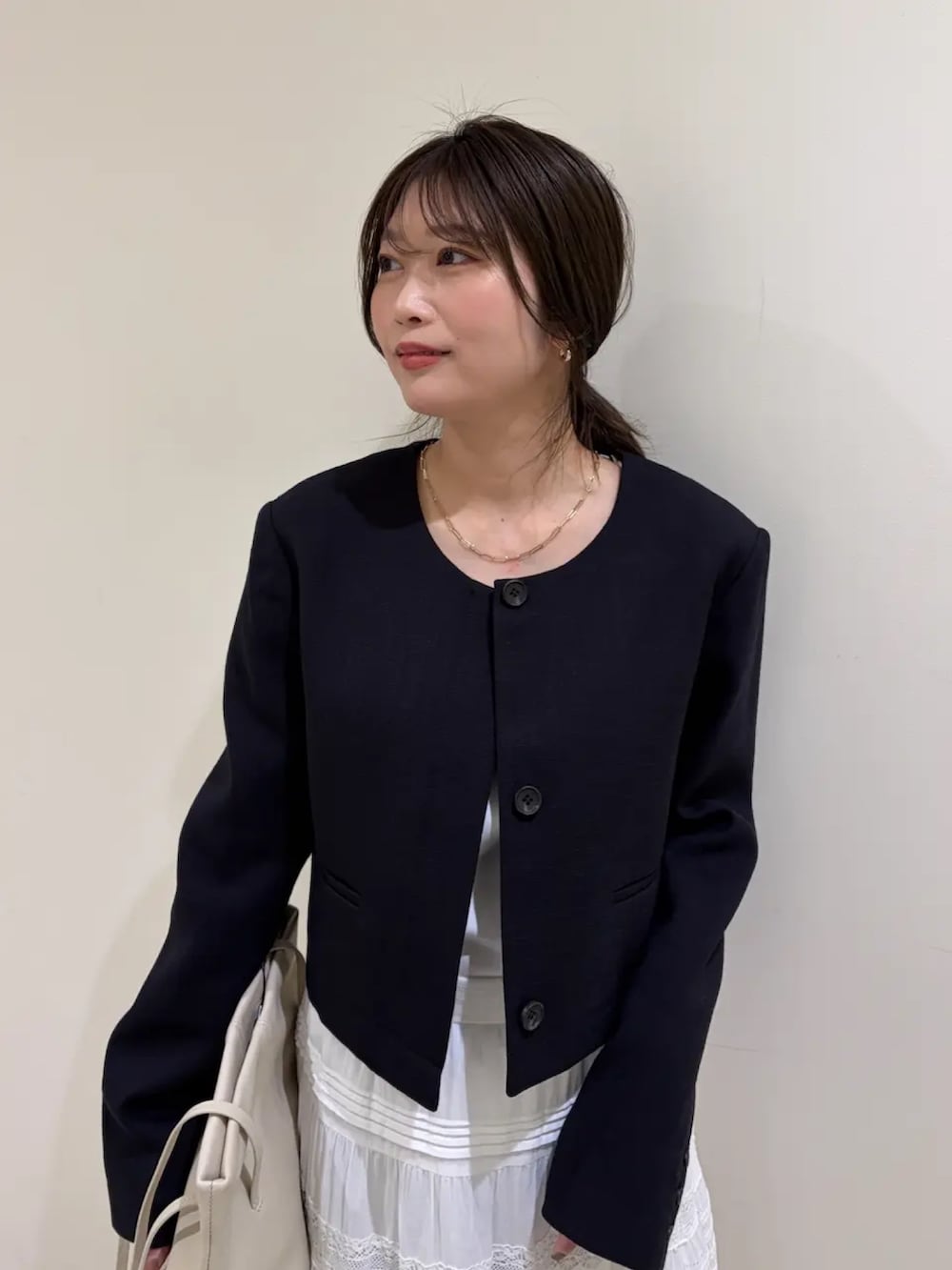 ブルー系のノーカラージャケット、ホワイト系のスカートを着用したレディースの春コーディネートの4枚目の写真