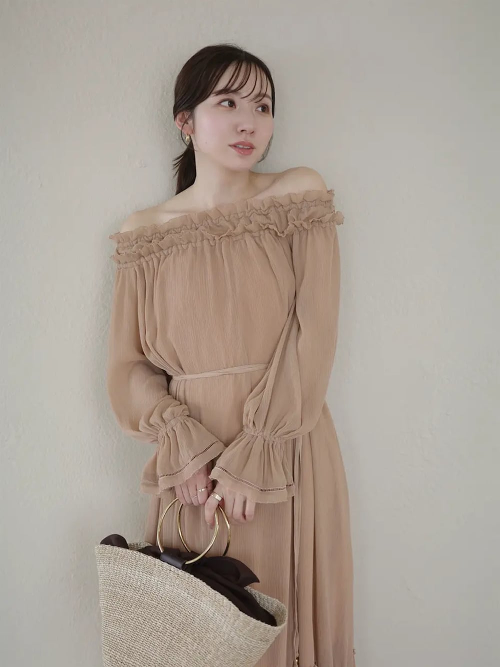 ブラウン系のワンピースを着用したレディースの春コーディネートの2枚目の写真