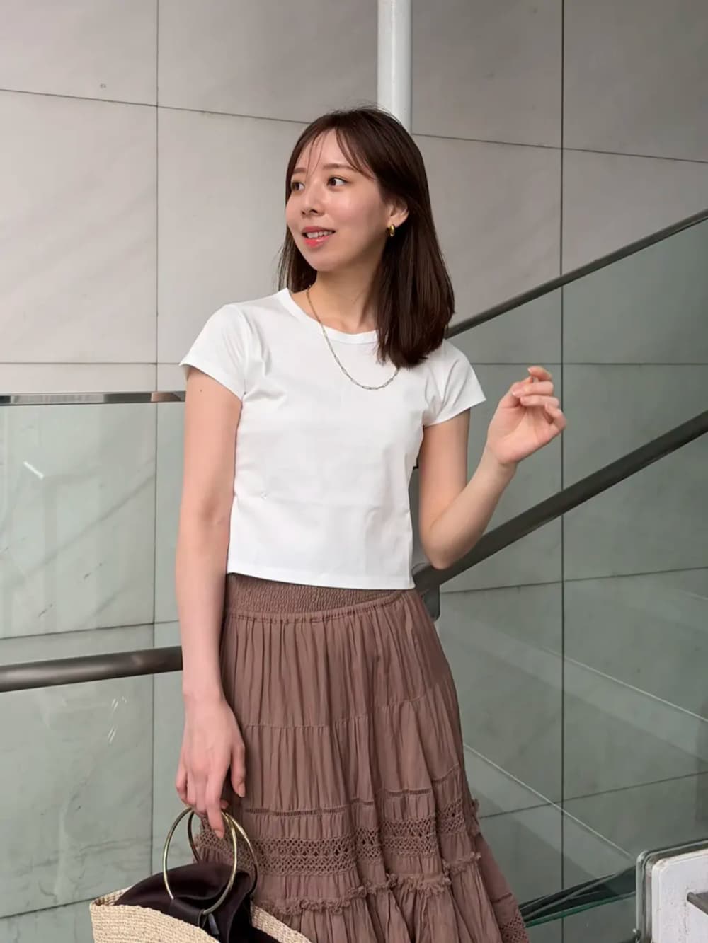 ホワイト系のTシャツ/カットソー、ブラウン系のスカート、ゴールド系のネックレスを着用したレディースの夏コーディネートの5枚目の写真