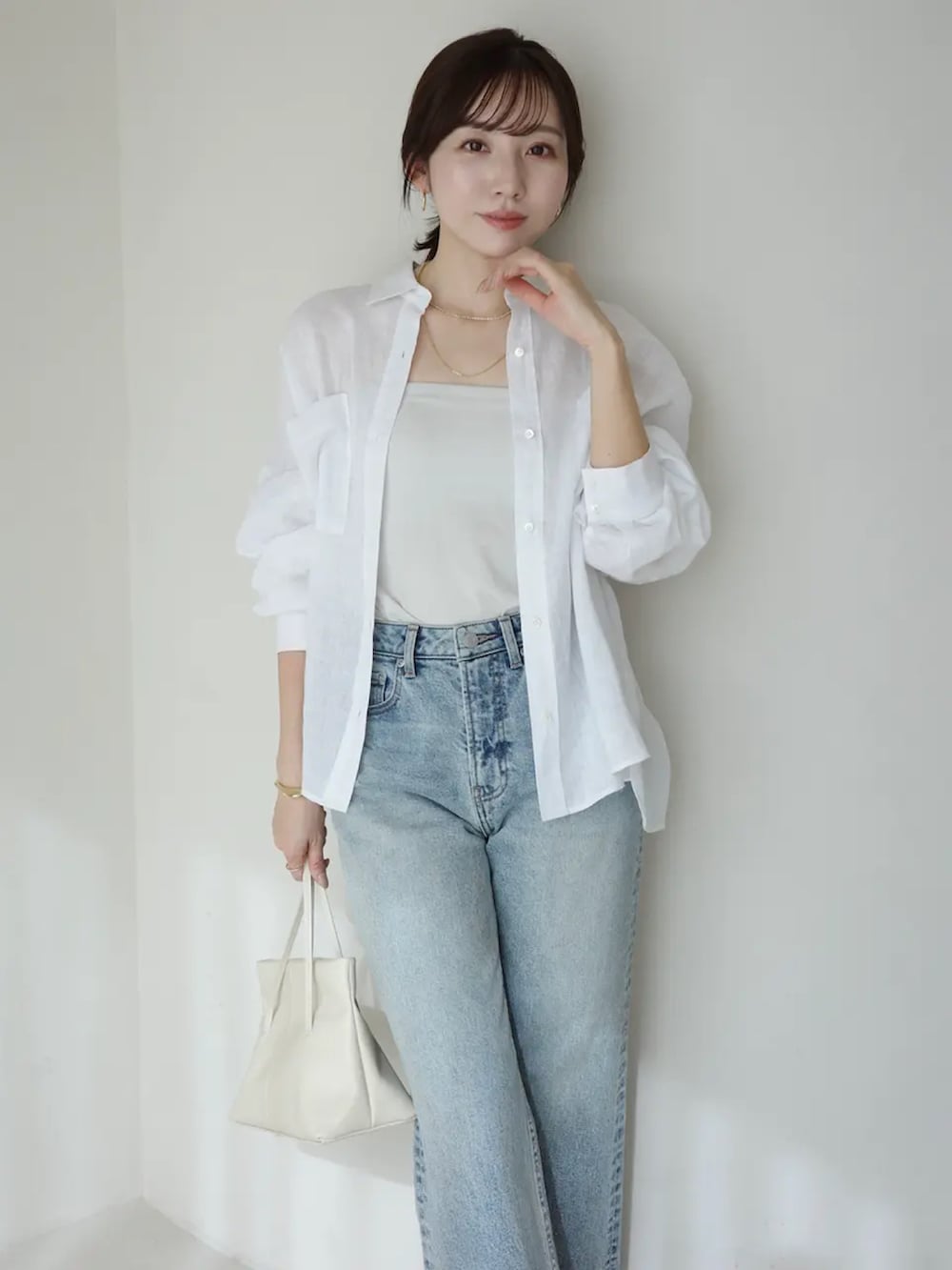 ホワイト系のシャツ/ブラウス、ブルー系のデニムパンツを着用したレディースの春コーディネートの3枚目の写真