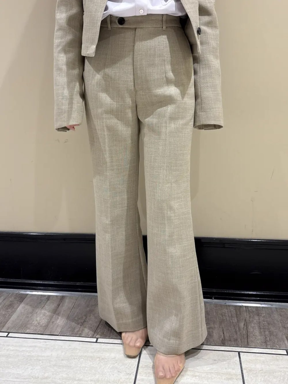 ベージュ系のスラックス、ベージュ系のノーカラージャケット、パープル系のシャツ/ブラウスを着用したレディースの春コーディネートの5枚目の写真